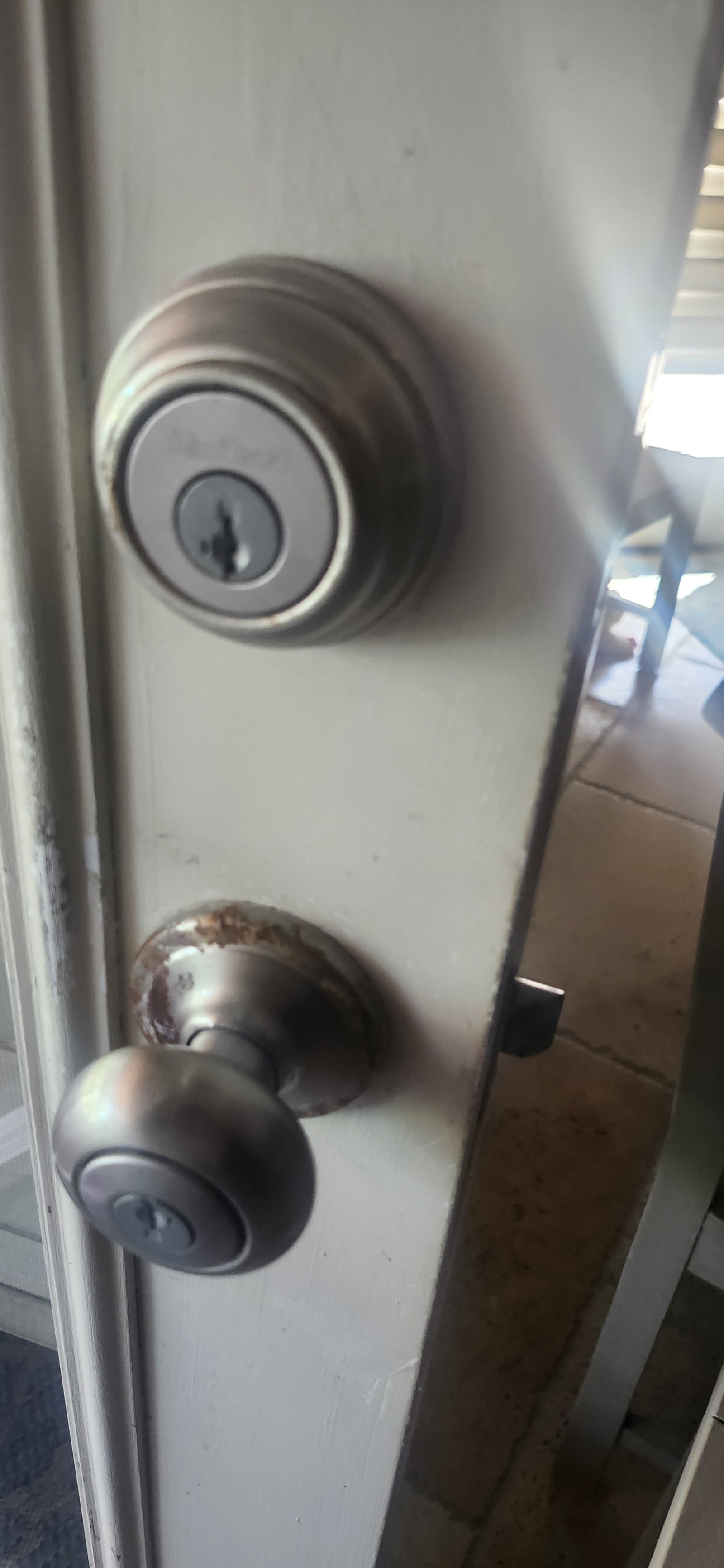 Worn door knob and deadbolt before lock replacement in Katy, TX