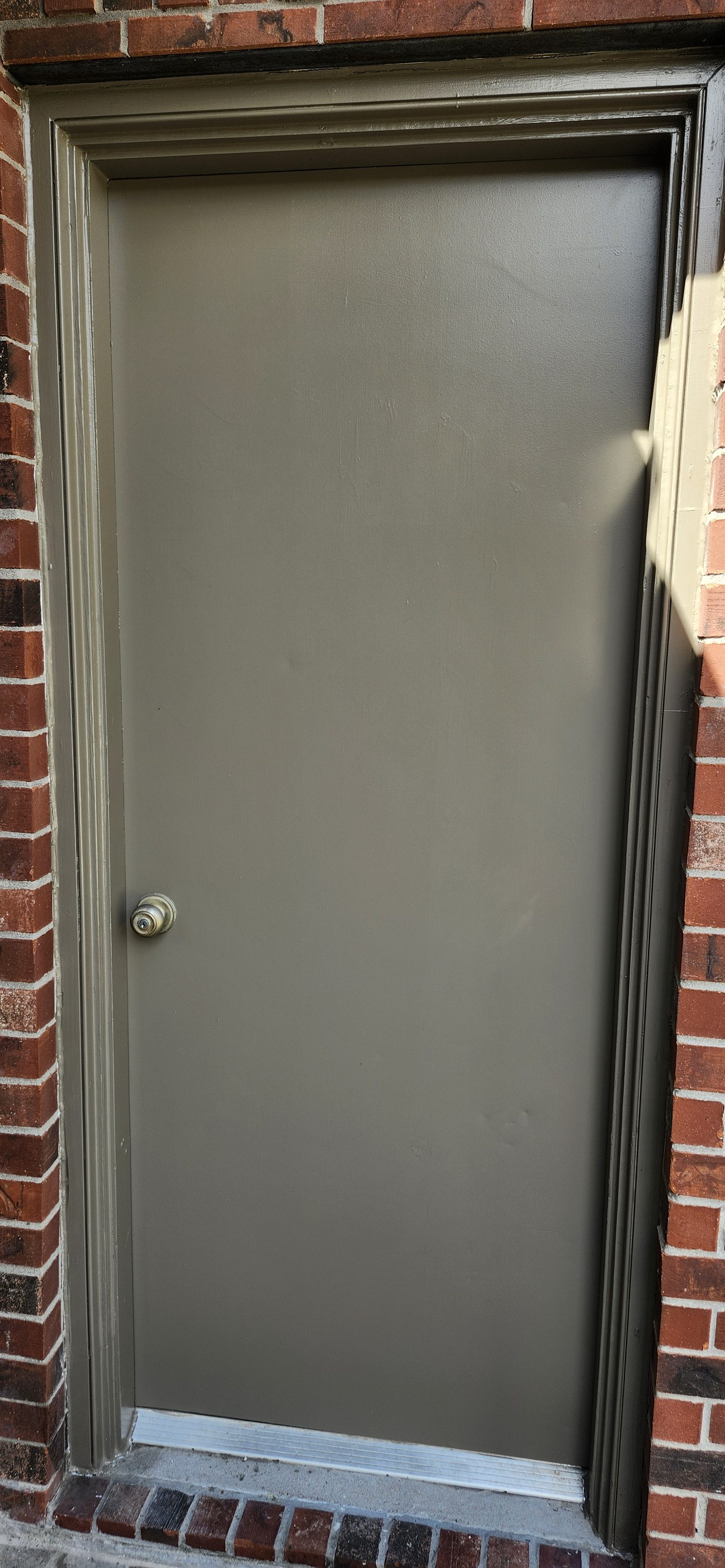 Dark navy front door with speakeasy grille after exterior painting in Katy, TX
