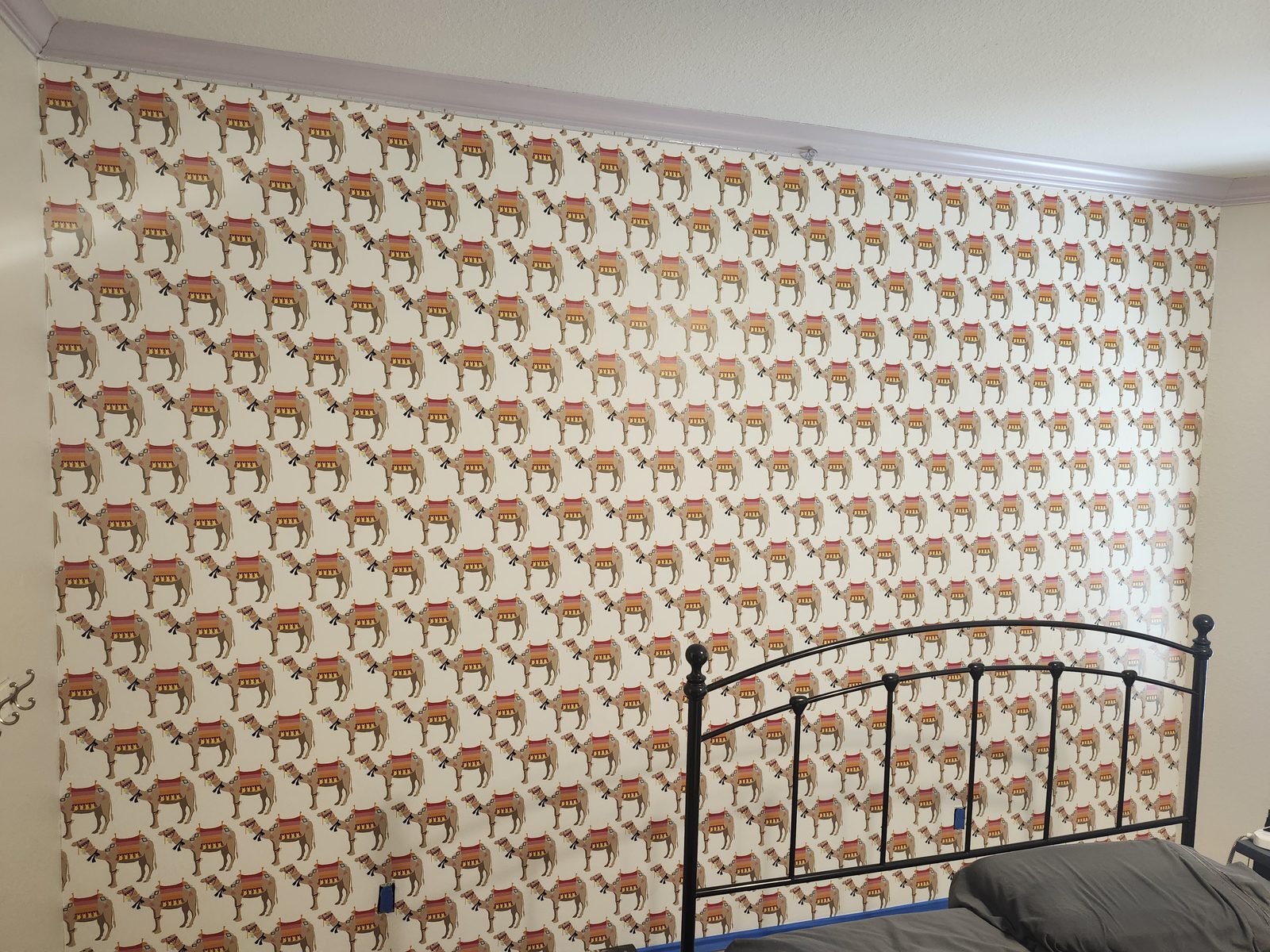 Bedroom wall with camel-pattern wallpaper before removal in Katy, TX