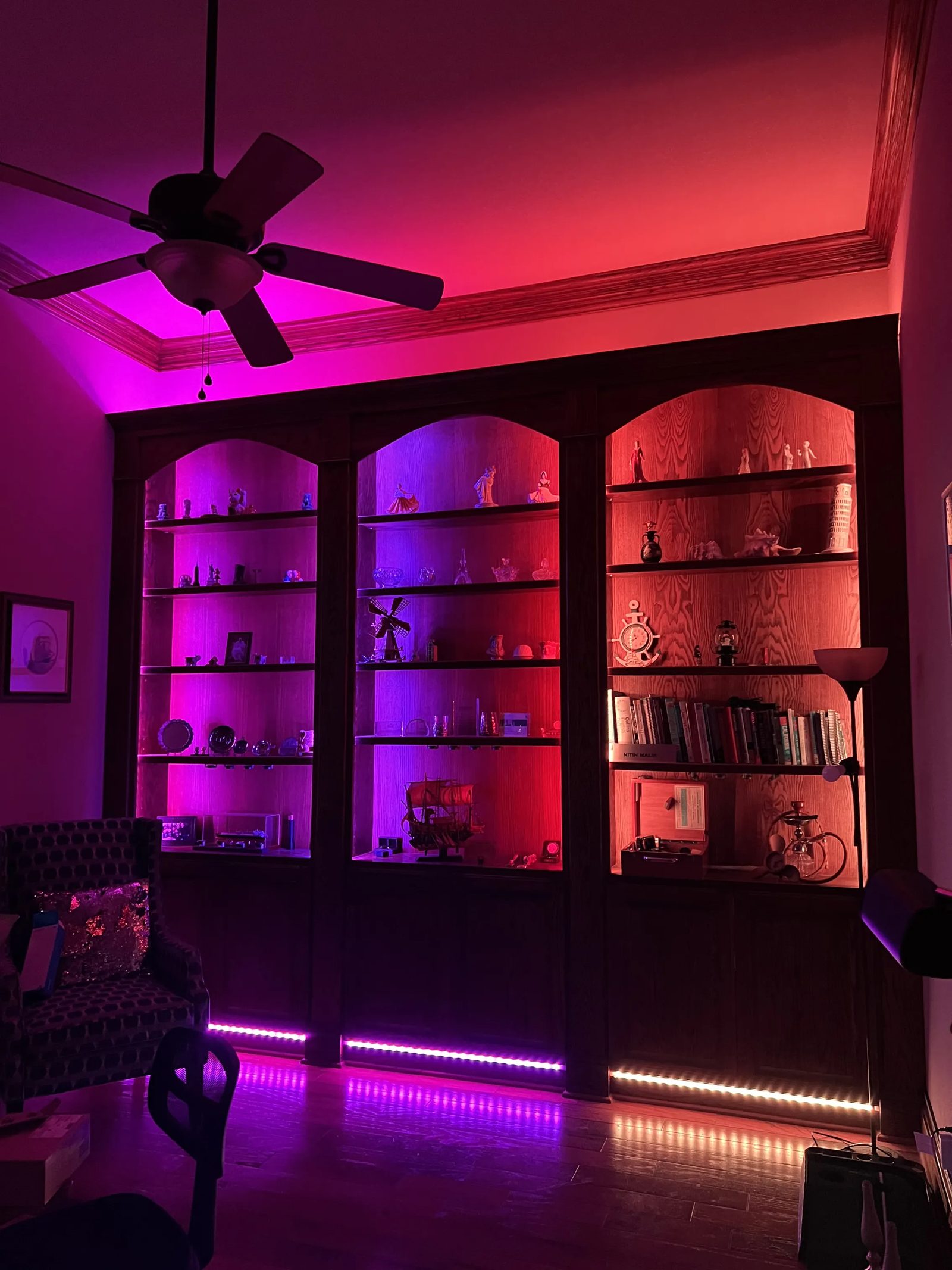 Red and purple LED accent lighting installed inside built-in office bookshelves in Katy, TX