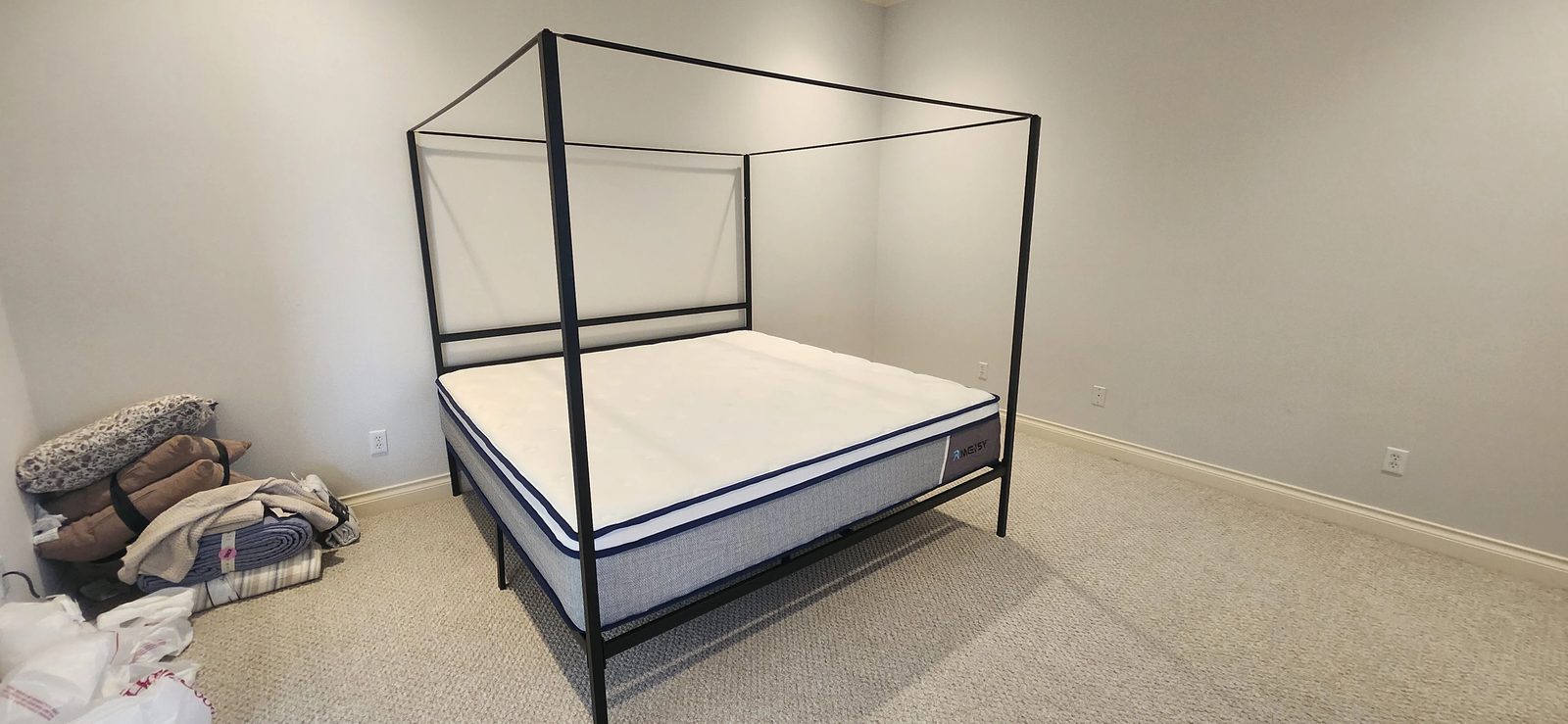 Assembled black canopy bed frame with mattress in Katy, TX