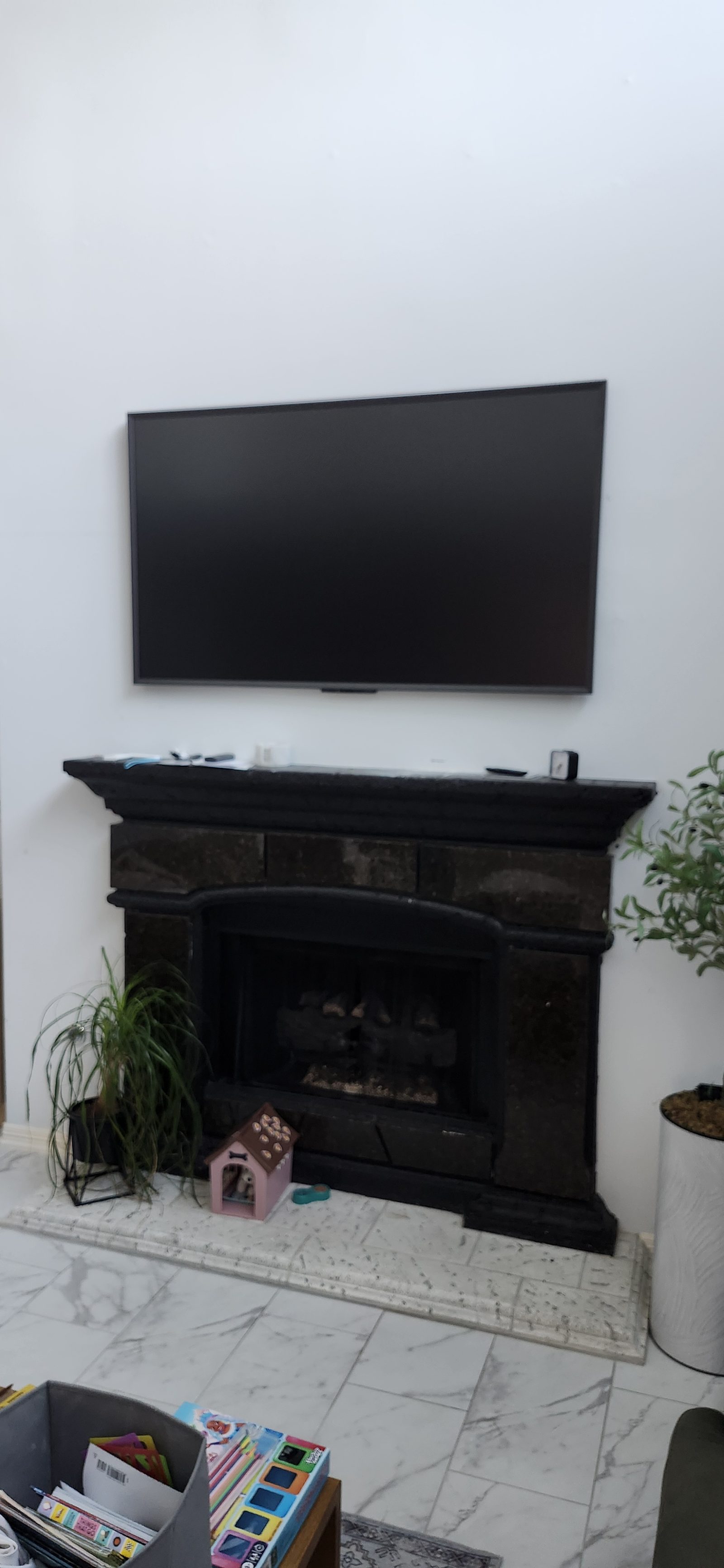 Flat-screen TV mounted above a fireplace in Katy, TX