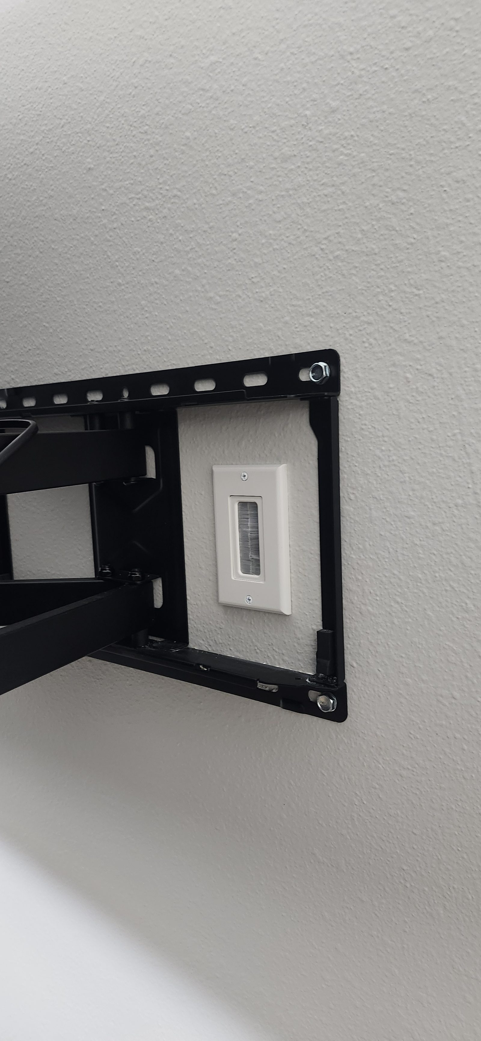 In-wall cable concealment outlet installed behind a mounted TV in Katy, TX