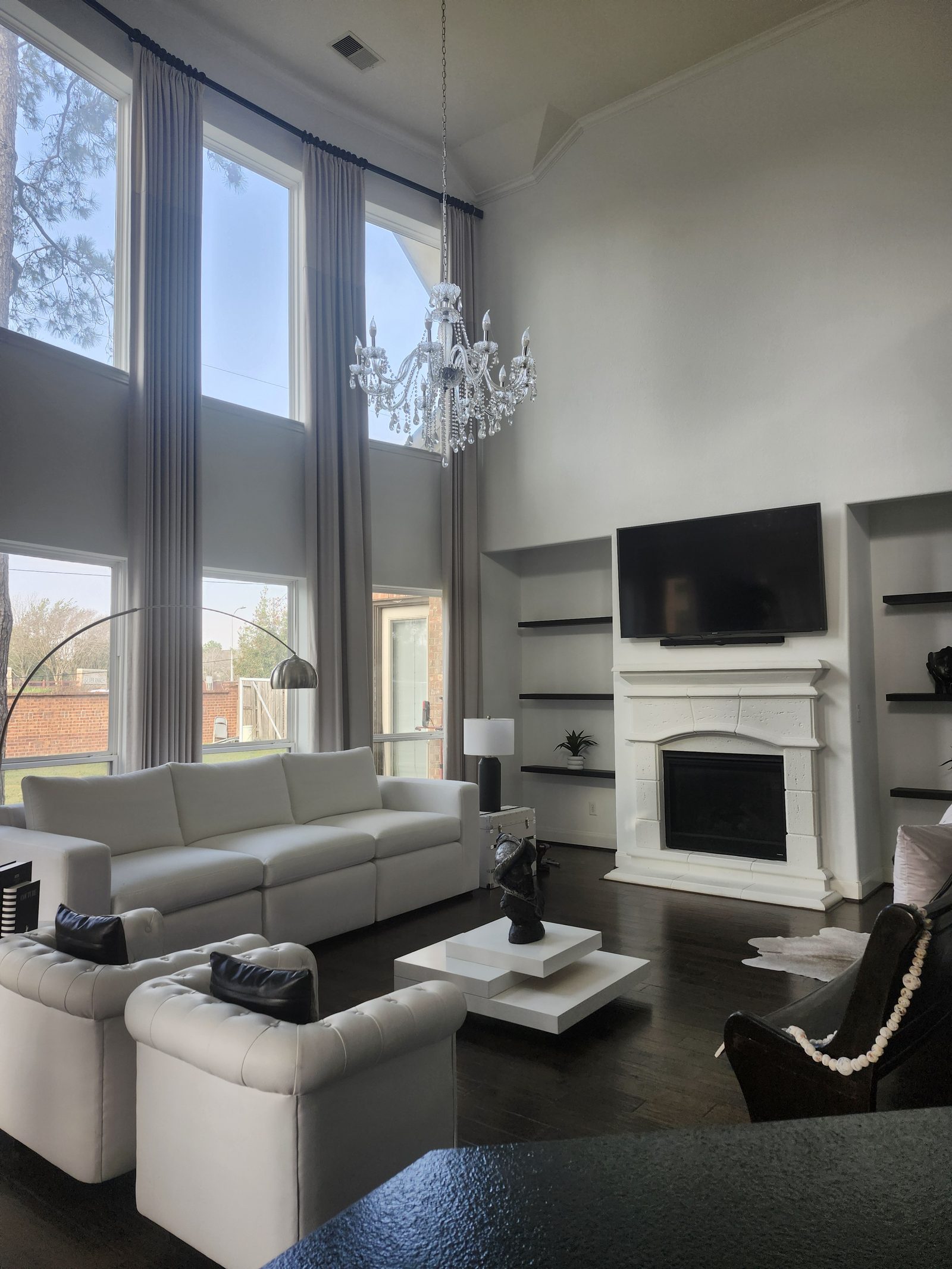 Living room with white walls and dark accent shelving after interior painting in Katy, TX