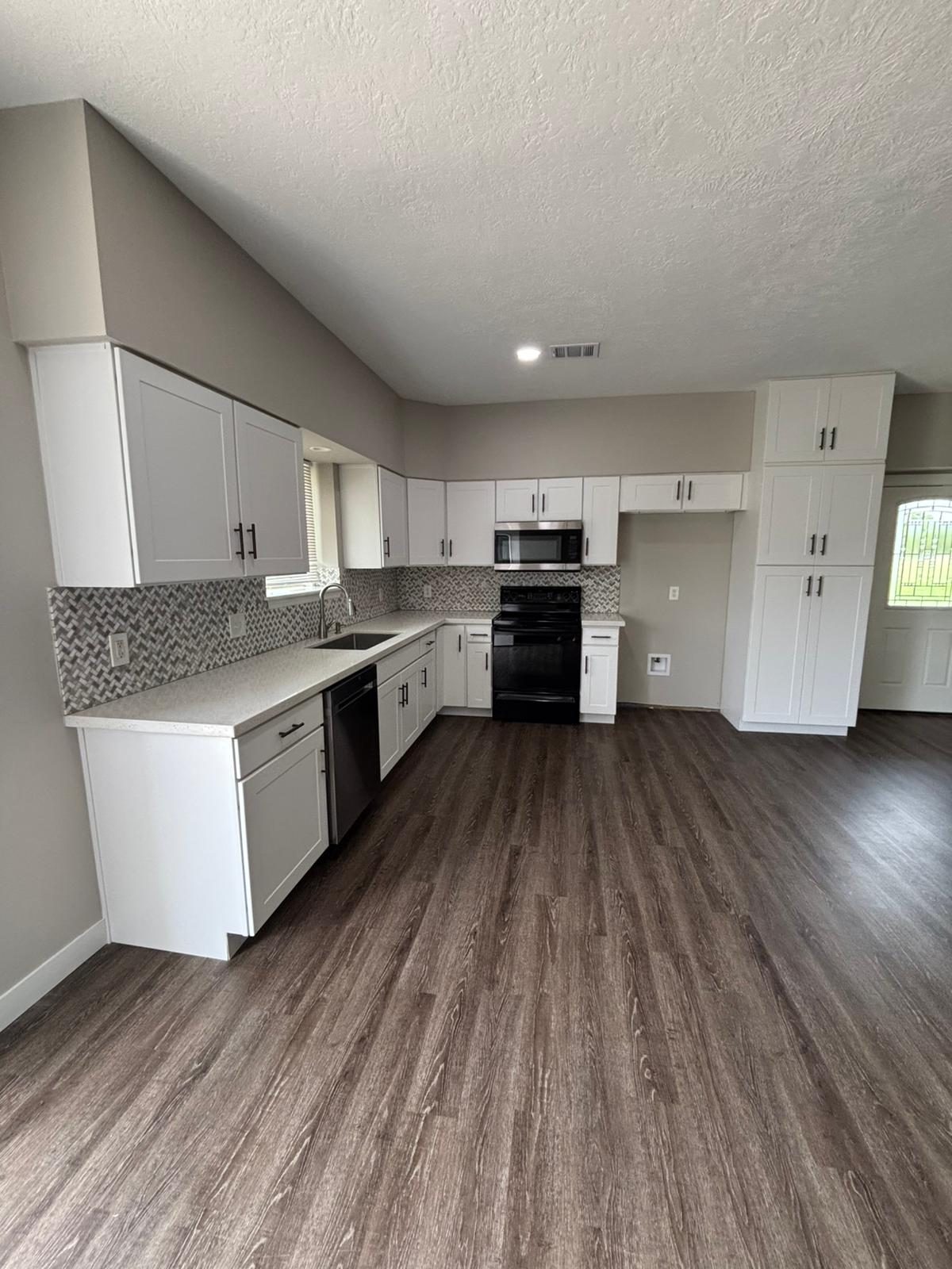 Kitchen with white cabinets and freshly painted walls in Katy, TX