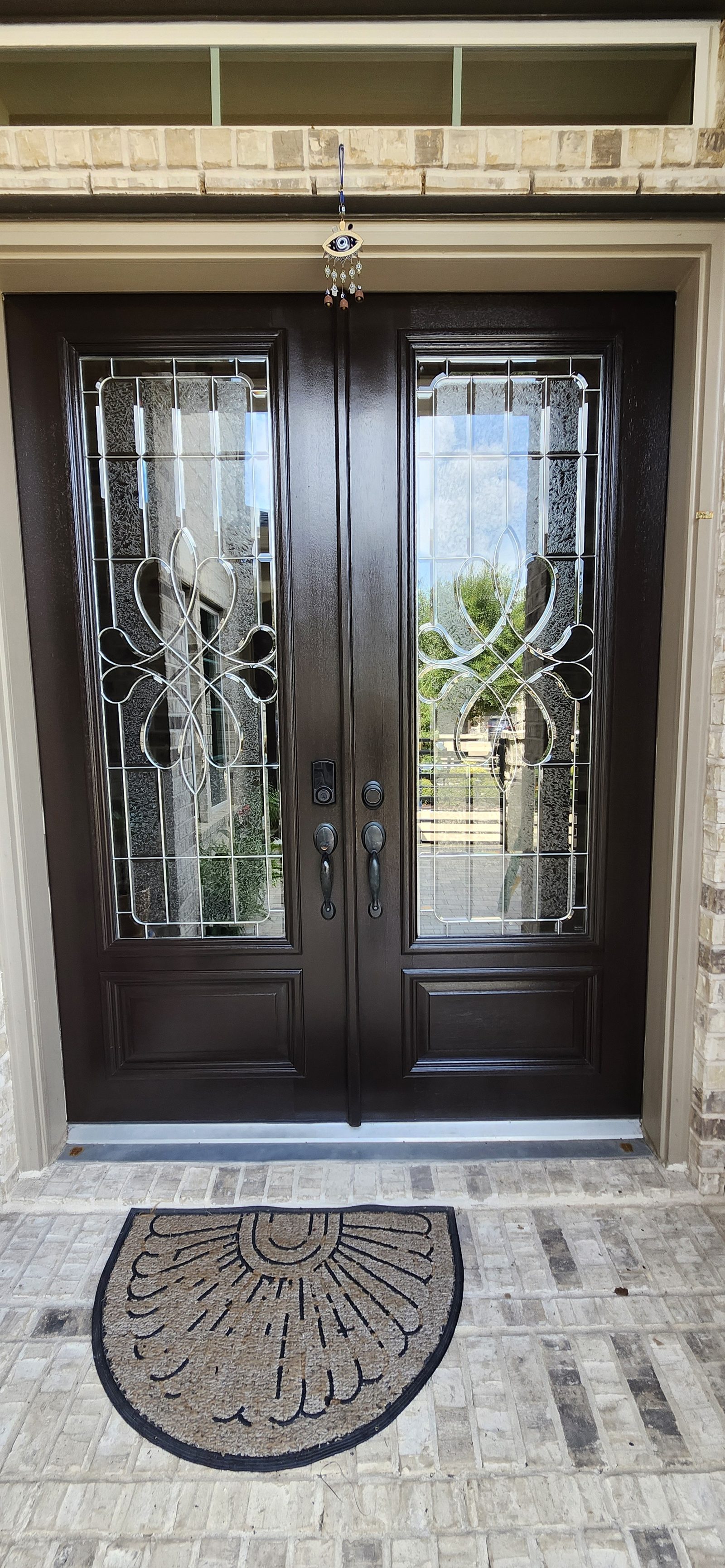 Dark stained double front doors with glass inserts in Katy, TX