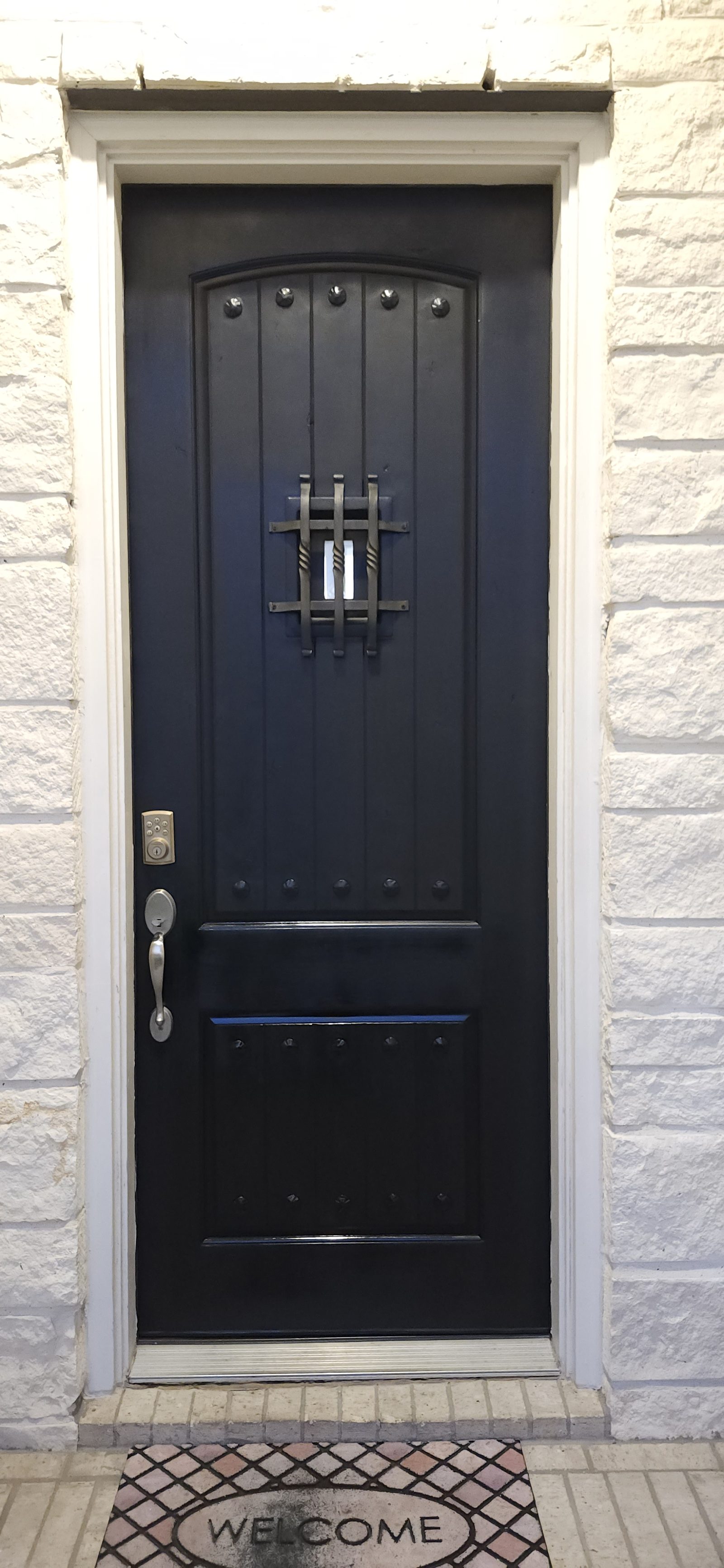 Dark navy front door with speakeasy grille after exterior painting in Katy, TX