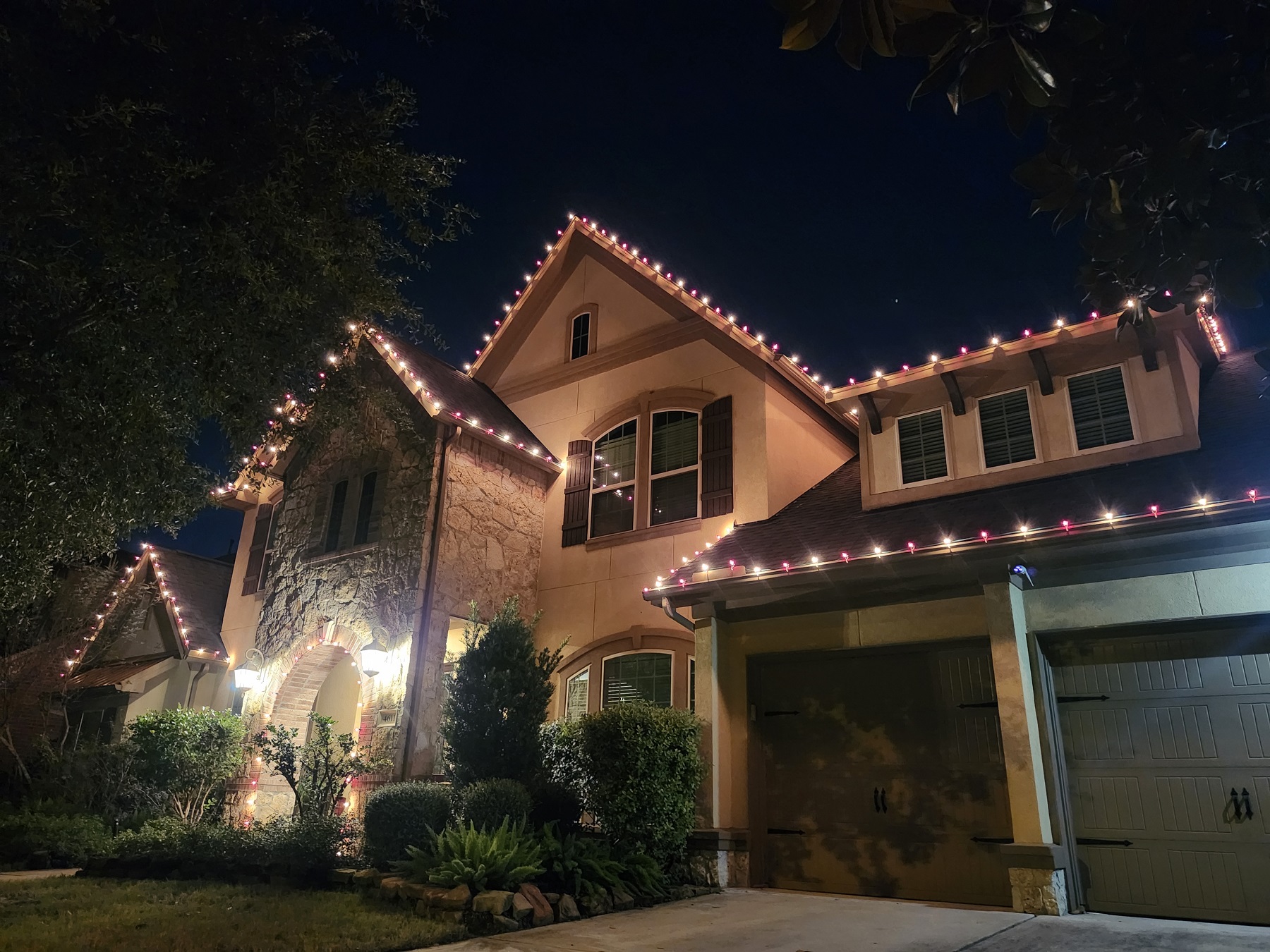 Christmas lights installation on two-story house in Katy, TX. Red and warm white pattern